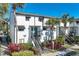 Two-story condo featuring tropical landscaping, black shutters, and a staircase leading to the front door at 4215 S Semoran Blvd # 2, Orlando, FL 32822