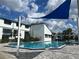 Community pool with a bright blue sunshade offering a refreshing and fun amenity for residents at 4215 S Semoran Blvd # 2, Orlando, FL 32822