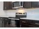 Close up on a modern kitchen featuring stainless steel appliances and dark cabinetry with white countertops at 4741 Sw 128Th St, Ocala, FL 34473