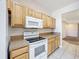 Well-lit kitchen featuring light wood cabinets, a white electric range, and matching white microwave at 4919 Culdesac Ct, St Cloud, FL 34772