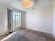 Sunlit living room with large window, modern light fixture, neutral carpet and walls create a calming atmosphere at 4919 Culdesac Ct, St Cloud, FL 34772