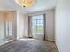 Bright living room featuring a large window and decorative chandelier with neutral carpet and light walls at 4919 Culdesac Ct, St Cloud, FL 34772
