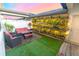Charming back patio with vertical garden, outdoor seating, artificial turf, and string lights perfect for entertaining at 5156 Caspian St, St Cloud, FL 34771