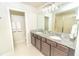 Bathroom featuring double sinks, a granite countertop, and a glass enclosed shower for a luxurious experience at 5156 Caspian St, St Cloud, FL 34771