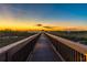 Picturesque boardwalk leading to a gazebo at sunset, offering serene views of the lake at 5156 Caspian St, St Cloud, FL 34771
