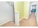 Well-lit upstairs hallway with carpet flooring and a colorful accent wall leading to the bedrooms at 5156 Caspian St, St Cloud, FL 34771
