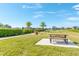 A lakeside picnic area with a fountain and community seating shaded by palm trees at 5156 Caspian St, St Cloud, FL 34771