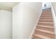 Carpeted staircase with white risers, leading to the upper level, provides a safe and stylish transition at 5156 Caspian St, St Cloud, FL 34771