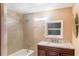 Well-lit bathroom featuring a shower-tub combo and vanity with a dark wood cabinet and granite countertop at 5424 Blue Grass St, Orlando, FL 32810