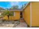 Close-up of a bright yellow home showcasing a well-kept lawn with a charming palm tree in a sunny neighborhood at 5424 Blue Grass St, Orlando, FL 32810