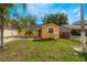 Charming yellow single-story home featuring a well-maintained lawn, palm tree, and inviting curb appeal under a sunny sky at 5424 Blue Grass St, Orlando, FL 32810