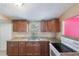 Kitchen featuring wood cabinets, granite countertops, a stainless sink, and modern appliances, offering functionality and style at 5424 Blue Grass St, Orlando, FL 32810