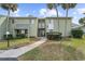 Exterior close up of condo units, sidewalk, well maintained lawn and shrubbery, and some palm trees at 543 Fairways Dr # B, Ocala, FL 34472