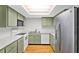 Kitchen with green cabinets, white appliances, hardwood floors, stainless refrigerator, and white countertops at 543 Fairways Dr # B, Ocala, FL 34472