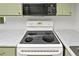 Kitchen features a range with coil burners and an overhead microwave, all set against light green cabinetry at 543 Fairways Dr # B, Ocala, FL 34472
