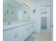 Bright bathroom featuring a double sink vanity, decorative art, and open doorway to shower at 5709 Sagunto Dr, Davenport, FL 33897