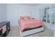 Bright bedroom with a white upholstered bed, pink bedding, and a sheer curtained window at 5709 Sagunto Dr, Davenport, FL 33897