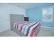 Comfortable bedroom features a plush bed, blue accent wall, and a view from the window at 5709 Sagunto Dr, Davenport, FL 33897