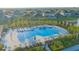 A large community swimming pool with lots of chairs and umbrellas surrounded by lush, tropical landscaping at 5709 Sagunto Dr, Davenport, FL 33897