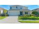 Charming two-story home featuring a well-manicured lawn and attached two-car garage at 5709 Sagunto Dr, Davenport, FL 33897