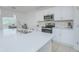Close up of an island in a bright, modern kitchen with stainless steel appliances and white countertops at 5709 Sagunto Dr, Davenport, FL 33897