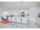 Bright, modern kitchen with white cabinetry, stainless steel appliances, a large island, and eat-in dining area at 5709 Sagunto Dr, Davenport, FL 33897