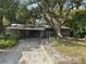 Single-story home with a carport and a driveway amidst lush, mature trees at 6 Barnard Ct, Maitland, FL 32751