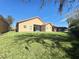 Expansive backyard with lush green grass, a well-maintained lawn, and a building in the background at 603 Russ Pond Dr, Kissimmee, FL 34759