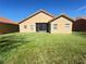 A view of the home's backyard with grass, screened-in patio and a glimpse of the red-tiled roof at 603 Russ Pond Dr, Kissimmee, FL 34759