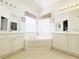 Bathroom with dual sinks, bathtub, and white cabinetry at 603 Russ Pond Dr, Kissimmee, FL 34759