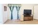 Bedroom with white walls, wood floors, a television, and green curtains at 603 Russ Pond Dr, Kissimmee, FL 34759