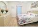 Cozy bedroom with floral bedding, neutral walls, laminate flooring, and dresser with mirror at 603 Russ Pond Dr, Kissimmee, FL 34759