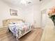 Bright bedroom with a floral comforter, light hardwood floors, and a ceiling fan at 603 Russ Pond Dr, Kissimmee, FL 34759