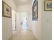 Hallway featuring tile floors, doorways to living areas, and decorative wall art at 603 Russ Pond Dr, Kissimmee, FL 34759