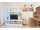 Bright living room with modern shelving, desk, and coastal decor, perfect for relaxing or entertaining at 603 Russ Pond Dr, Kissimmee, FL 34759
