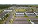 Aerial view of neighborhood with townhomes, garages, and a central park with a playground at 6067 Blue Lily Way, Winter Garden, FL 34787