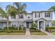 Inviting townhome featuring a manicured lawn, gray siding, and dark shutters at 6067 Blue Lily Way, Winter Garden, FL 34787