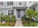 Charming entryway with a walkway, palm tree, and lush landscaping at 6067 Blue Lily Way, Winter Garden, FL 34787