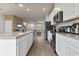 Bright kitchen features white cabinetry, stainless steel appliances, and an open view to the living room at 6067 Blue Lily Way, Winter Garden, FL 34787