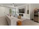 Bright living room with gray sofa, modern fireplace, large tv, and a wine cooler at 6067 Blue Lily Way, Winter Garden, FL 34787