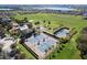 Aerial view showcasing community tennis courts, pool, clubhouse, and lush green spaces at 637 Conservation Blvd, Groveland, FL 34736