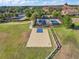 Aerial view showcasing tennis and basketball courts surrounded by lush landscaping at 637 Conservation Blvd, Groveland, FL 34736