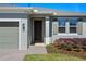 Welcoming front entrance with a brick walkway, tidy landscaping, and a gray door at 637 Conservation Blvd, Groveland, FL 34736