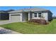 Charming home featuring a well-manicured lawn, two-car garage, and neutral-colored facade at 637 Conservation Blvd, Groveland, FL 34736