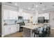 A modern kitchen features white cabinets, an island with barstool seating, and stainless steel appliances at 637 Conservation Blvd, Groveland, FL 34736