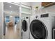 Laundry room area complete with modern washer and dryer machines, and tiled floor at 637 Conservation Blvd, Groveland, FL 34736