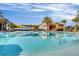 Tranquil pool reflecting palm trees and covered seating areas on a sunny day at the community clubhouse at 637 Conservation Blvd, Groveland, FL 34736
