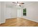 Bright bedroom with wood floors, ceiling fan, and access to the ensuite bathroom at 703 Sailfish Rd, Winter Springs, FL 32708