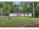 Single-story home featuring a green lawn, landscaping, and a vibrant red front door at 703 Sailfish Rd, Winter Springs, FL 32708