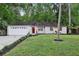 Charming single-story home with a well-manicured lawn, red door, and attached garage at 703 Sailfish Rd, Winter Springs, FL 32708